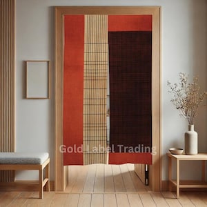 Può includere: Un paio di divisori per ambienti con un motivo geometrico in tonalità di arancione, marrone e beige. I divisori sono in tessuto e hanno un fiocco in basso. I divisori sono appesi a una porta.