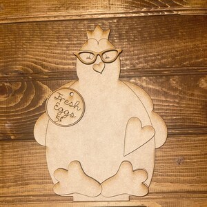 May include: Wooden cutout of a chicken wearing glasses and a crown, holding a sign that says "Fresh Eggs 5¢". The chicken is sitting on a wooden base with a slot for money.