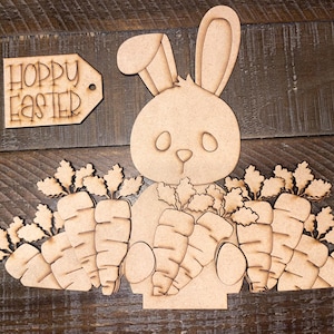 May include: Wooden craft kit featuring a bunny rabbit holding carrots. The kit includes a sign that says "Hoppy Easter".