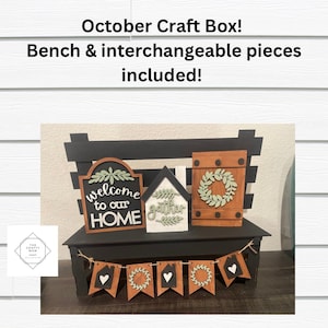 May include: A black wooden bench with a shelf and interchangeable wooden signs. The signs feature a welcome to our home message, a gather sign, and a wreath. The bench is decorated with a banner of flags with wreaths and hearts.