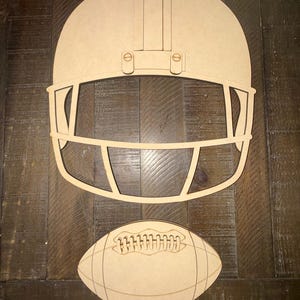 May include: A light brown, flat, laser-cut wooden cutout of a football helmet with a face mask and a separate, smaller, flat, laser-cut wooden cutout of an American football with etched lace and panel details, both featuring a smooth, matte finish.