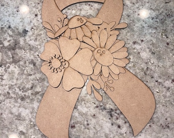 May include: A wooden cutout of a ribbon with flowers. The ribbon is brown and the flowers are white with brown centers. The ribbon has two holes at the top for hanging.