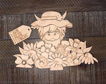 May include: Wooden craft kit featuring a Highland cow wearing a hat and holding a bouquet of flowers. The kit includes a sign that says "Farm Fresh Flowers".
