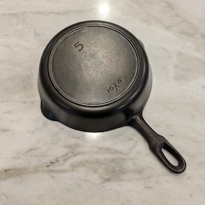 May include: A black cast iron skillet with a 5 inch diameter and the numbers "1030" stamped on the bottom.