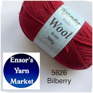 May include: A skein of Wendy Pure Wool Aran yarn in the colour 5626 Bilberry. The yarn is a deep red colour and is labelled with the brand name and weight.