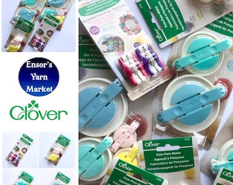 May include: A close-up of several Clover brand pom-pom makers in various sizes. The packaging features the text "Pom-Pom Maker" and "Beautiful Pom-Poms Made Easy".