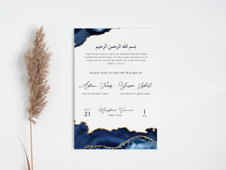 May include: A cream-coloured invitation card with navy blue and gold watercolour details. The card features elegant calligraphy and includes Arabic script, English text, and event details for a wedding.
