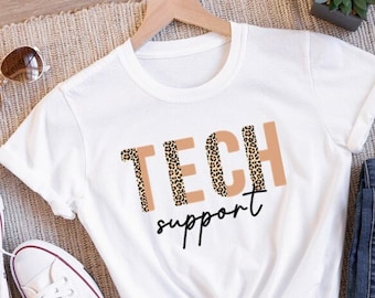May include: White t-shirt with the text "TECH support" in brown with a leopard print pattern.
