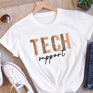 Puede incluir: Camiseta blanca con el texto "TECH support" en marrón con un estampado de leopardo.