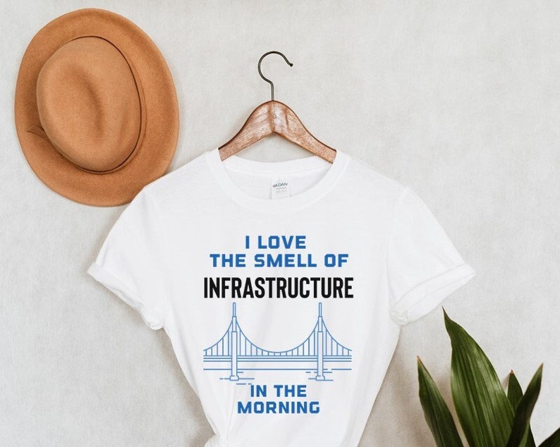 May include: White t-shirt with a blue and black graphic of a bridge and the text "I love the smell of infrastructure in the morning".