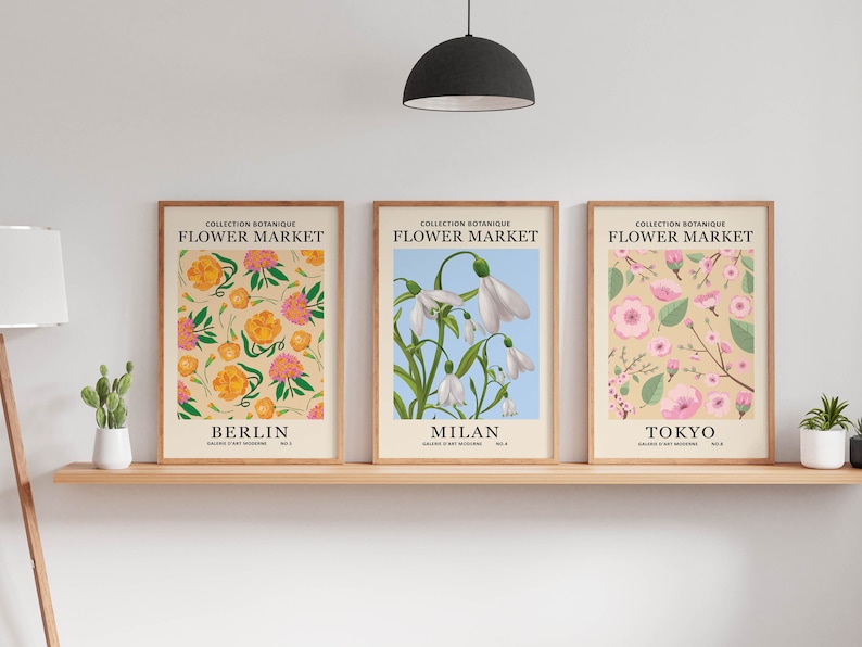 Puede incluir: Tres impresiones bot&aacute;nicas enmarcadas con el t&iacute;tulo "Flower Market" y las ciudades "Berl&iacute;n", "Mil&aacute;n" y "Tokio" debajo. Las impresiones presentan diferentes patrones florales en tonos de rosa, amarillo, blanco y verde.