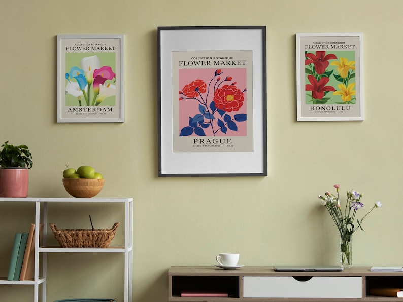 Puede incluir: Tres impresiones bot&aacute;nicas enmarcadas con el t&iacute;tulo "Flower Market" y los nombres de las ciudades "Amsterdam", "Praga" y "Honolulu". Cada impresi&oacute;n presenta un tipo de flor diferente en un dise&ntilde;o colorido y estilizado.