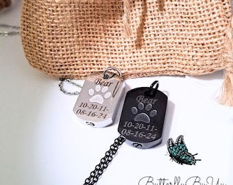 Puede incluir: Dos collares con medallas de perro de plata con grabados de huellas de patas. Las medallas están grabadas con el nombre "Bear" y las fechas "10-20-11" y "08-16-24". Una medalla es plateada y la otra es negra.