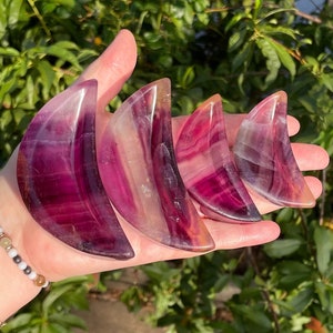 Peut inclure: Quatre cristaux de fluorine en forme de croissant de lune dans des tons de rose, violet et blanc. Les cristaux sont dispos&eacute;s en rang&eacute;e, le plus grand &agrave; gauche et le plus petit &agrave; droite.