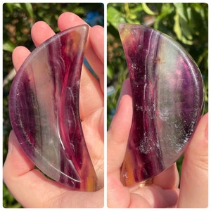 Peut inclure: Un cristal de fluorine en forme de croissant de lune avec des bandes violettes, vertes et jaunes. Le cristal est poli et lisse.