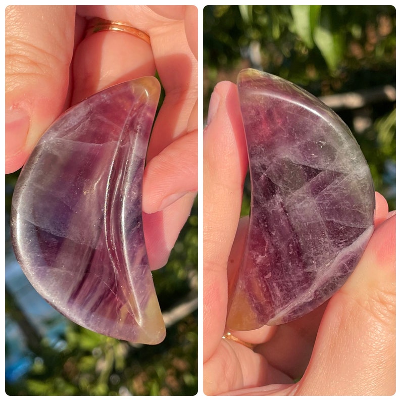 Peut inclure: Un cristal de fluorite violet et vert sculpt&eacute; en forme de croissant de lune. Le cristal est poli et a une surface lisse et brillante.
