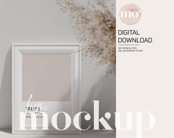 May include: White frame mockup with a light pink background. The frame is sitting on a white surface with a dried flower arrangement in the background. The text "mockup" is written in white letters on the image.