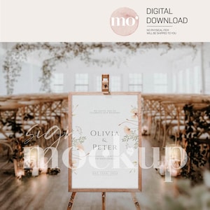 May include: A wedding sign mockup with a wooden frame and easel. The sign has a watercolor floral design with the text "We invite you to celebrate our wedding Olivia & Peter 4 o'clock in the afternoon the white church Dec 12th, 2022".
