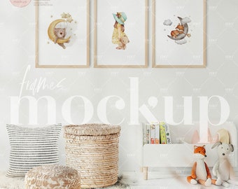 Op de afbeelding: Drie ingelijste illustraties van een beer, een meisje en een vos, allemaal met een maan- en sterrenmotief. De lijsten hangen aan een witte muur boven een wit boekenrek met boeken en knuffels.