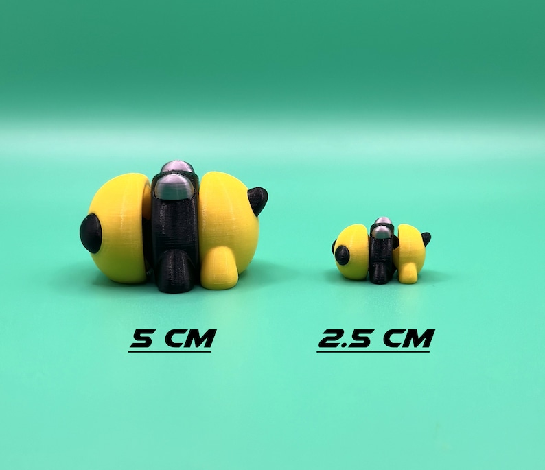 May include: Two 3D printed bee figurines, one yellow and black with silver accents, the other smaller and yellow and black. The larger bee is 5 inches long, the smaller bee is 2.5 inches long.