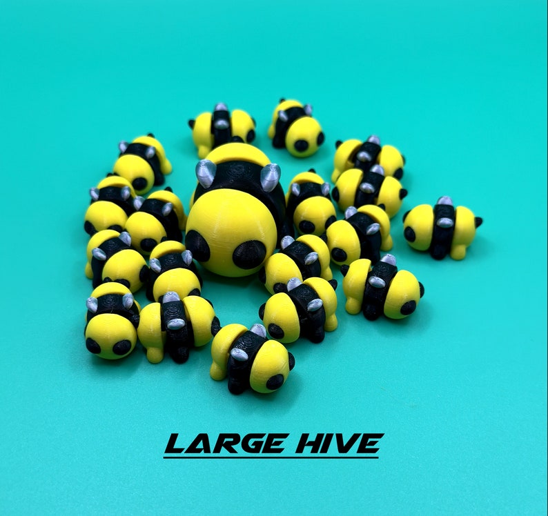 May include: A large group of yellow and black bee figurines with silver accents. The bees are arranged in a cluster, resembling a beehive. The figurines are made of plastic and have a glossy finish.