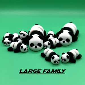 Puede incluir: Una gran familia de 9 figuras de panda blanco y negro, todas tumbadas sobre una superficie verde. El texto "LARGE FAMILY" est&aacute; impreso debajo de las figuras.