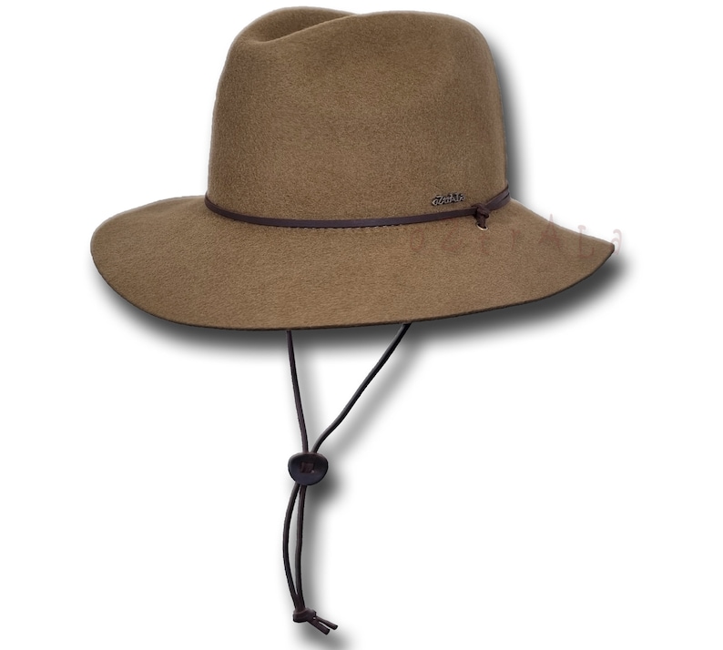 May include: A brown felt fedora hat with a wide brim and a brown leather band. The hat has a chin strap with a brown button.