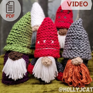 Puede incluir: Cuatro gnomos de punto con sombreros y barbas de diferentes colores. Los gnomos llevan sombreros verdes, rojos, blancos y grises. Los gnomos tienen barbas blancas, blancas, blancas y naranjas. Los gnomos están sentados sobre una superficie verde. VIDEO