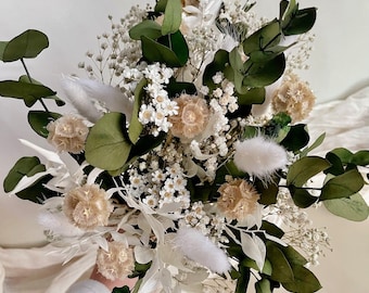 Pode incluir: Um buquê de flores secas com flores brancas e bege, caules brancos e fofinhos e folhas verdes de eucalipto.