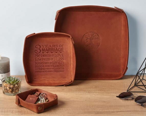Hand-stitched leather valet tray that gets stamped with a name or initials — the kind of desk/dresser upgrade that feels like a proper grown-up accessory.