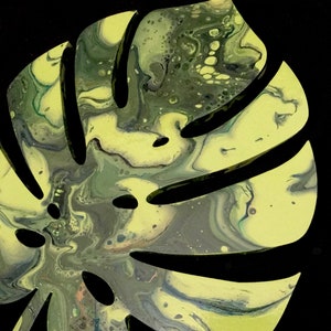 Puede incluir: Un recorte con forma de hoja de monstera que presenta un dise&ntilde;o de vertido de acr&iacute;lico fluido en tonos verde lima, verde bosque oscuro y gris pizarra. La superficie muestra patrones marmolados y arremolinados con formas org&aacute;nicas.