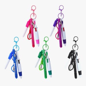 May include: A collection of keychains, each featuring a pen, a small pair of scissors, and a penlight. The keychains come in various colors, including pink, purple, blue, green, and black. The pens and penlights are white with colored accents.