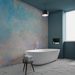 May include: A white bathtub with a blue and pink abstract wall mural behind it. The bathroom has a blue wall, a white window with blinds, and a white marble floor.