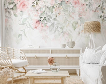 May include: A living room interior design with a white couch, a wicker chair, a wooden coffee table, and a white cabinet with a book titled "Home Philosophy" on top. The wall is decorated with a floral wallpaper featuring pink and green watercolor flowers.