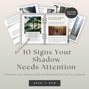 May include: An open binder with pages featuring text and images, including the title "10 Signs Your Shadow Needs Attention." A pen rests on the pages. The text "Embrace Your Shadow Side and Manifest the Life You Deserve" is also visible.