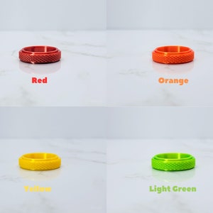 May include: Four different colored rings with a textured surface. The rings are red, orange, yellow, and light green.