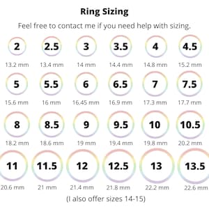 Puede incluir: Un gr&aacute;fico que muestra los tama&ntilde;os de los anillos del 2 al 13,5, con las medidas correspondientes en mil&iacute;metros. El gr&aacute;fico tambi&eacute;n incluye el texto "Ring Sizing" y "No dudes en contactarme si necesitas ayuda con el tama&ntilde;o." El gr&aacute;fico est&aacute; sobre un fondo blanco con c&iacute;rculos de colores arco&iacute;ris.