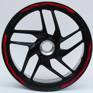 Peut inclure: Jante de roue de moto noire avec des bandes de course rouges. La roue a un design à cinq branches.