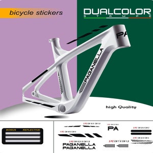Puede incluir: Un cuadro de bicicleta blanco con pegatinas de doble color negro. Las pegatinas muestran el texto "PAGANELLA" y "PA". Las pegatinas son reflectantes y vienen en varios tamaños. La imagen también muestra una pegatina reflectante de bonificación con tres rayas.