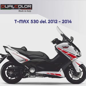 Può includere: Uno scooter T-MAX 530 bianco e nero con strisce rosse da corsa. Lo scooter ha un sedile nero e un parabrezza trasparente. Il testo "T-MAX 530 del 2012 - 2014" è visibile. Prodotto in Italia.