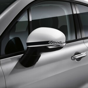 Peut inclure: Un rétroviseur de voiture blanc avec un autocollant de bande de course à damier noir et blanc. Le rétroviseur est fixé à une portière de voiture argentée.