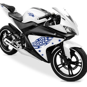 Può includere: Una moto bianca con strisce da corsa blu e bianche e adesivi a forma di stella. La moto ha una sella nera e uno scarico nero.