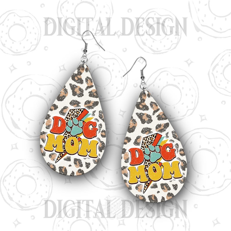 May include: A pair of dangle earrings with a leopard print background and the text "Dog Mom" in colorful retro lettering.