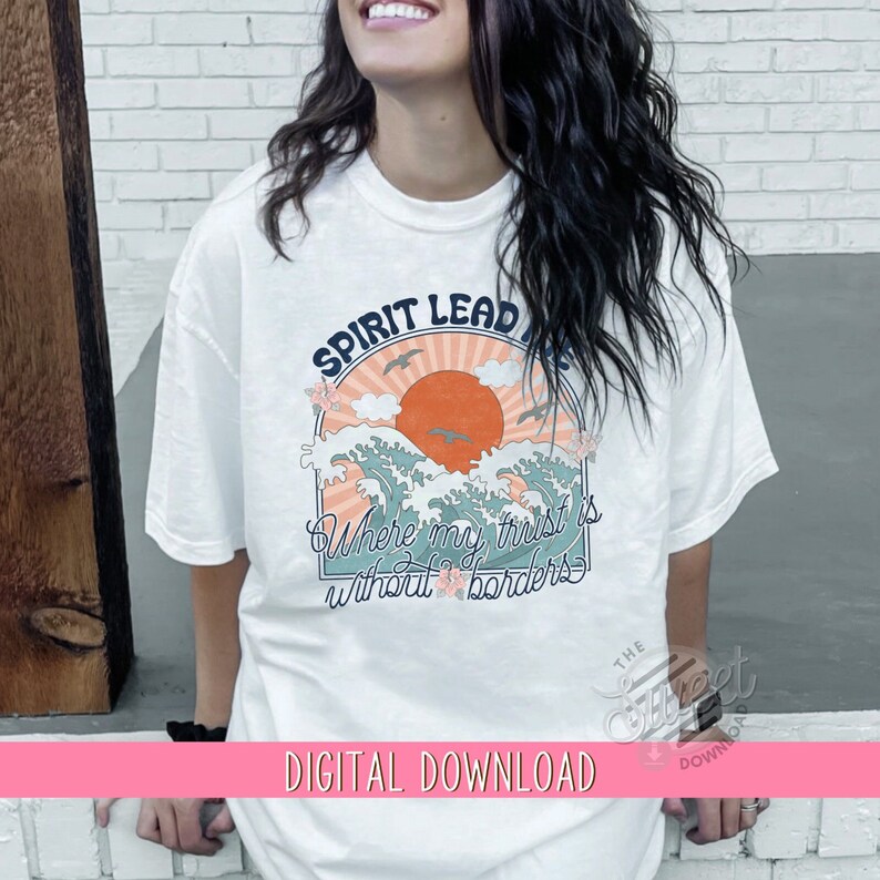 May include: White t-shirt featuring a graphic design of a sunset over waves with the text "Spirit Lead Me Where My Trust Is Without Borders".