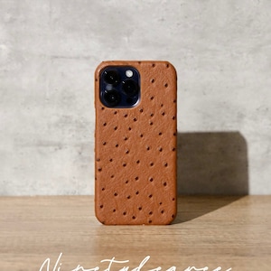 May include: A brown leather phone case with a textured ostrich skin pattern. The case has a cutout for the phone's camera lenses.
