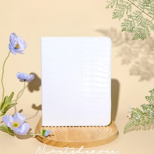 Capa para iPad em couro branco cremoso com estampa de crocodilo e compartimento para acessórios. Compatível com iPad Pro 2022, 2021, iPad Air 2026-24, iPad Air 5-1, iPad 2025-19 e iPad mini 6-4.