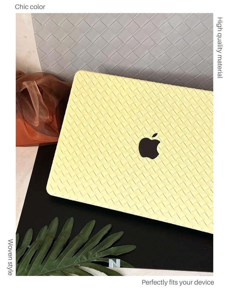 May include: A pale yellow laptop cover featuring a woven texture pattern. The cover has a cutout in the centre revealing a black Apple logo. The text on the image includes Chic colour, High quality material, Woven style, and Perfectly fits your device.