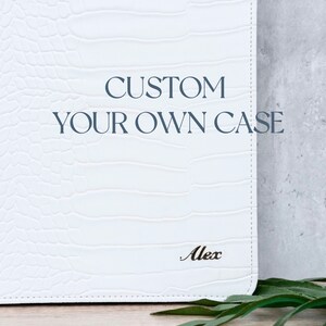 May include: White custom case with the text "CUSTOM YOUR OWN CASE" and the name "Alex" embossed on the front.