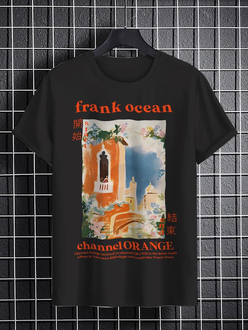 May include: Black t-shirt with a graphic print of a building with a balcony and flowers. The text "frank ocean" is printed in red above the graphic. The text "channel ORANGE" is printed in red below the graphic. The text "開始" and "結束" are printed in red on the left and right sides of the graphic, respectively.