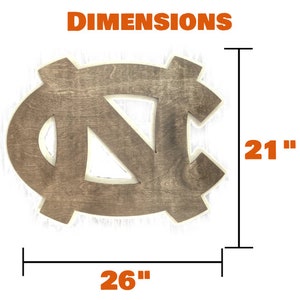 Puede incluir: Un recorte de madera del logotipo de los Tar Heels de la Universidad de Carolina del Norte. El logotipo es marr&oacute;n con un contorno blanco y mide 66 cent&iacute;metros de ancho por 53 cent&iacute;metros de alto.